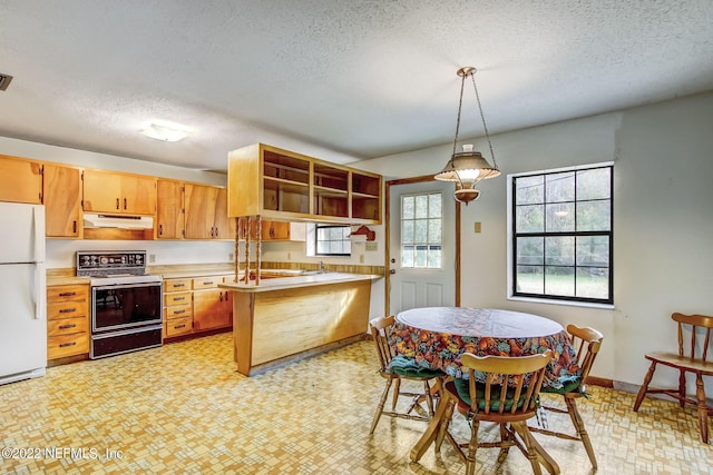 kitchen featuring range with electric stovetop, kitchen peninsula, hanging light fixtures, white refrigerator, and a textured ceiling