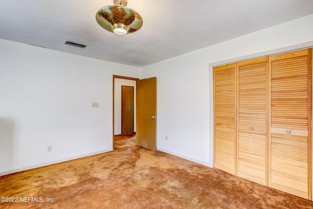 unfurnished bedroom with a closet, carpet, and a textured ceiling