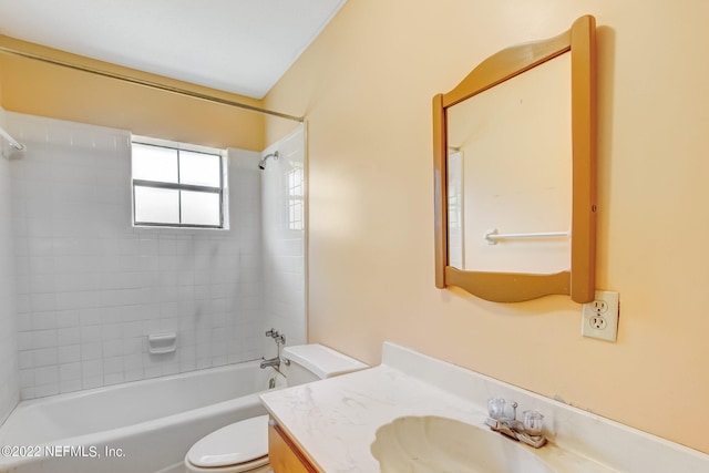 full bathroom featuring tiled shower / bath, vanity, and toilet