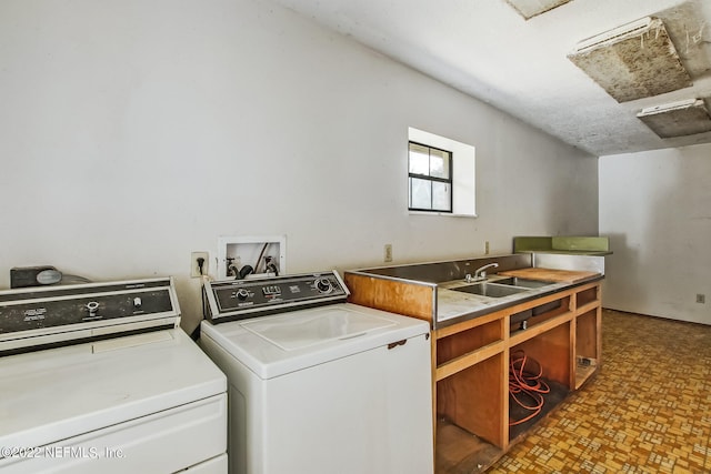 laundry room with cabinets, a textured ceiling, sink, and separate washer and dryer