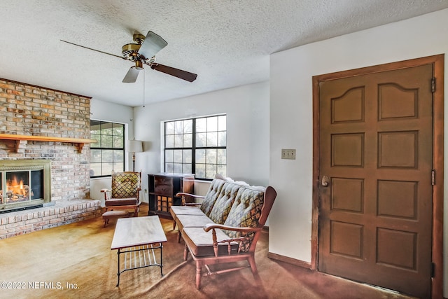 living room featuring ceiling fan, a textured ceiling, carpet floors, and a fireplace