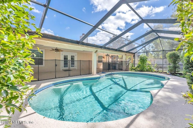 view of pool featuring a patio area, glass enclosure, french doors, and ceiling fan