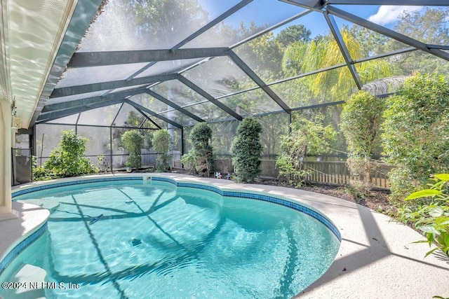 view of swimming pool featuring glass enclosure