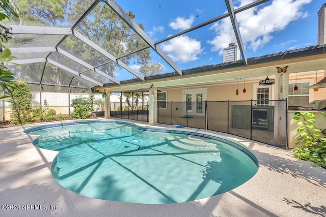 view of pool with ceiling fan, area for grilling, a patio, a lanai, and french doors