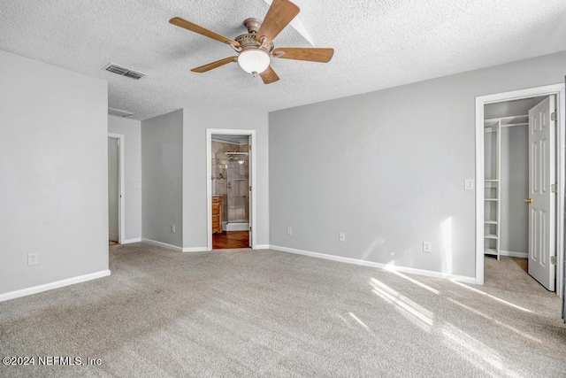 unfurnished bedroom featuring light carpet, a textured ceiling, and ceiling fan