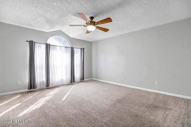 unfurnished room with vaulted ceiling, a textured ceiling, carpet floors, and ceiling fan