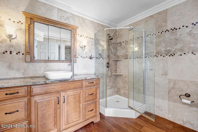 bathroom featuring vanity, crown molding, a shower with door, and hardwood / wood-style floors