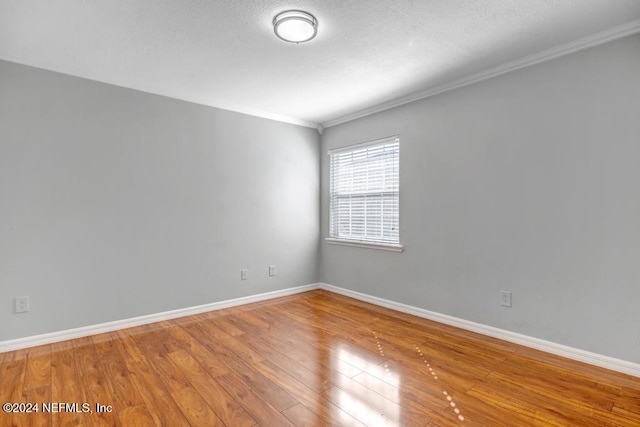 unfurnished room featuring ornamental molding and wood-type flooring