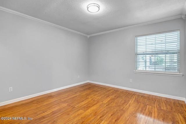 spare room featuring ornamental molding, hardwood / wood-style floors, and a textured ceiling