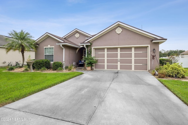 single story home featuring a front lawn and a garage