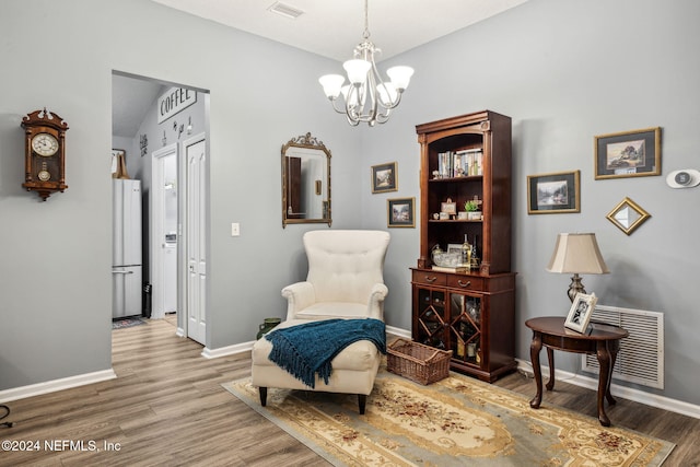 living area featuring wood-type flooring and an inviting chandelier