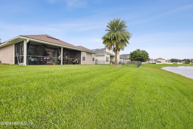 view of yard featuring a water view and a sunroom