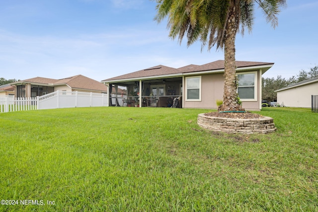 back of house featuring a yard and a sunroom