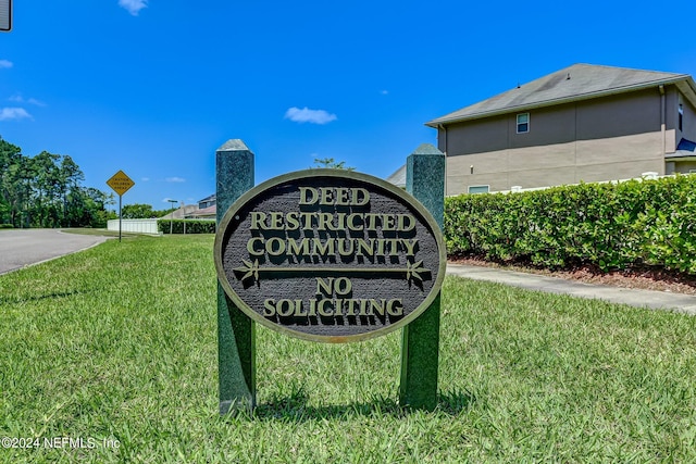 community sign featuring a yard