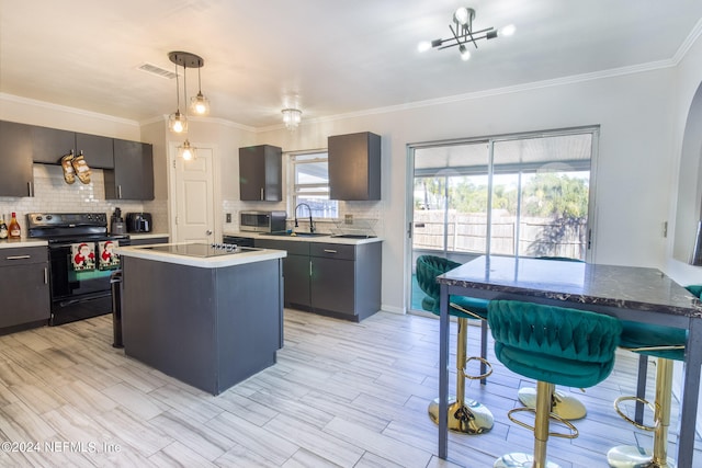 kitchen featuring crown molding, black appliances, a wealth of natural light, and a kitchen island