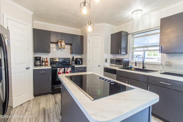 kitchen with black appliances, sink, a kitchen island, hanging light fixtures, and decorative backsplash