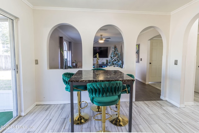 dining space with ornamental molding, light hardwood / wood-style floors, and ceiling fan