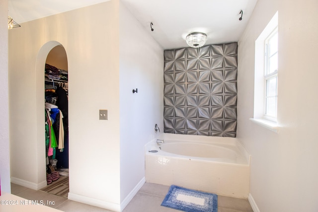 bathroom with a tub to relax in and tile patterned floors