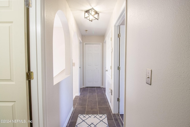 corridor featuring dark tile patterned flooring