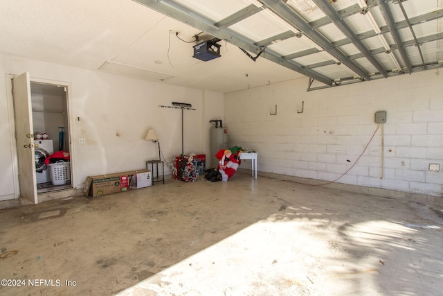 garage featuring washer / clothes dryer, a garage door opener, and electric water heater