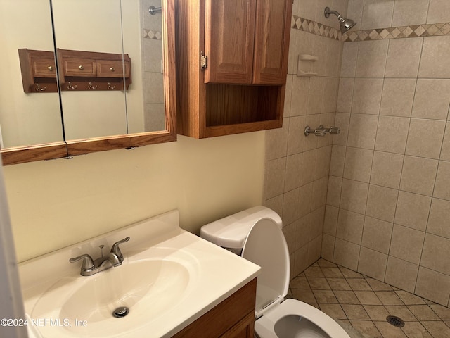 bathroom featuring tiled shower, vanity, and toilet