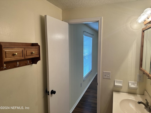 bathroom featuring hardwood / wood-style floors, vanity, and a textured ceiling