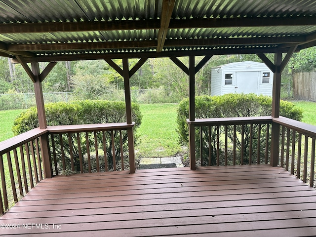 wooden terrace with a yard and a storage shed