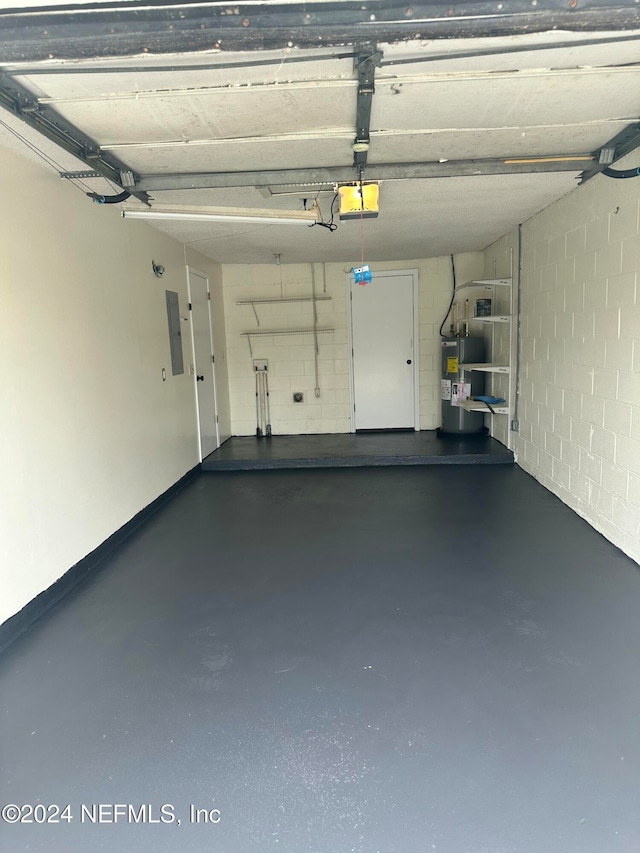 garage featuring electric water heater, electric panel, and a garage door opener