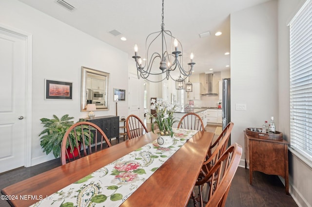 dining space featuring dark wood-type flooring and a notable chandelier