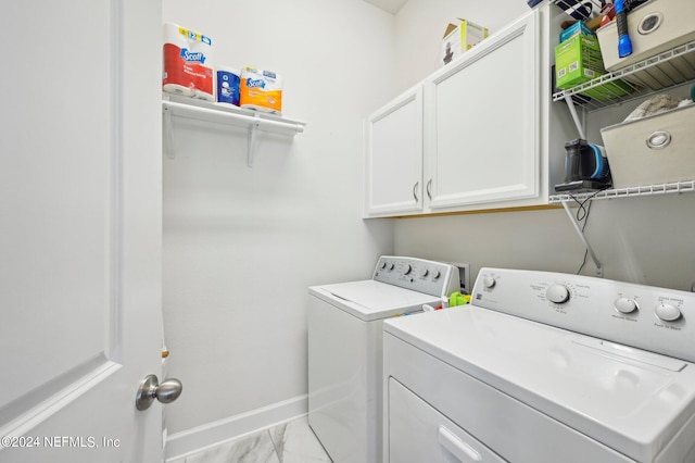 washroom featuring cabinets and separate washer and dryer