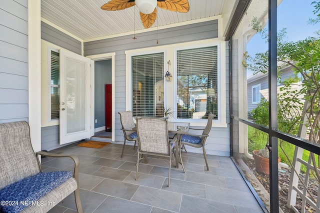 sunroom / solarium featuring wood ceiling, ceiling fan, and a wealth of natural light