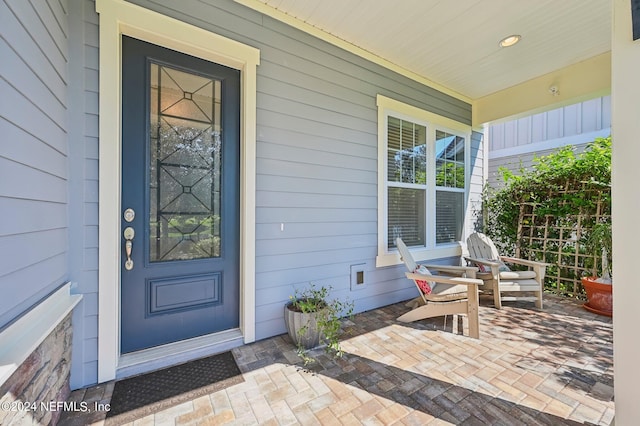 view of exterior entry featuring covered porch