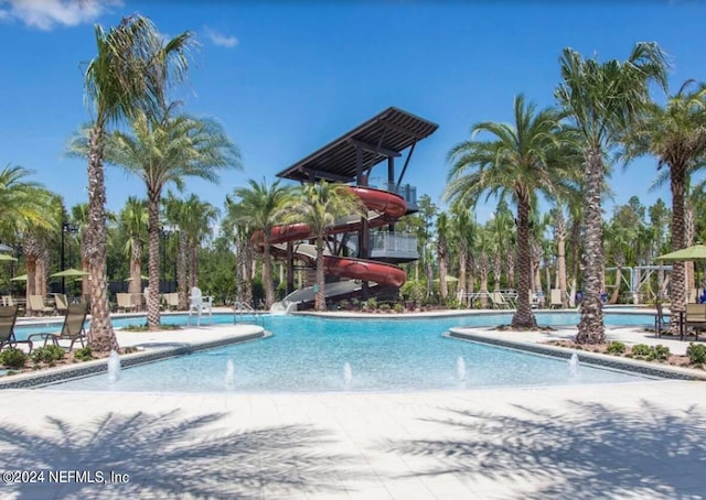 view of swimming pool featuring a water slide and pool water feature