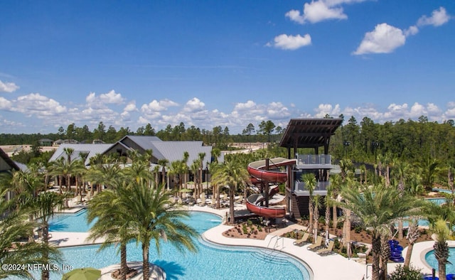 view of swimming pool with a water slide and a patio area