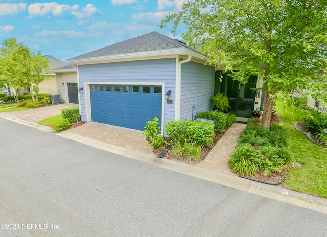 view of front of home featuring central AC and a garage