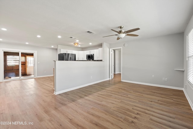 unfurnished living room with ceiling fan and light wood-type flooring