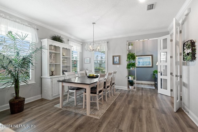 dining room with a textured ceiling, ornamental molding, dark hardwood / wood-style floors, a notable chandelier, and french doors