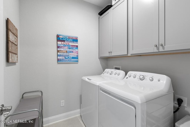 washroom with light tile patterned flooring, separate washer and dryer, and cabinets