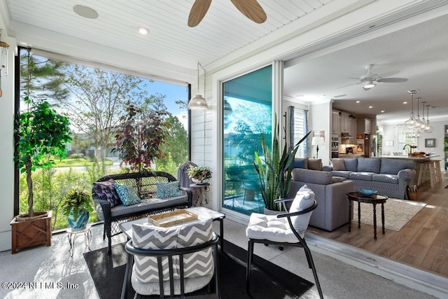 sunroom / solarium with wood ceiling, plenty of natural light, and ceiling fan