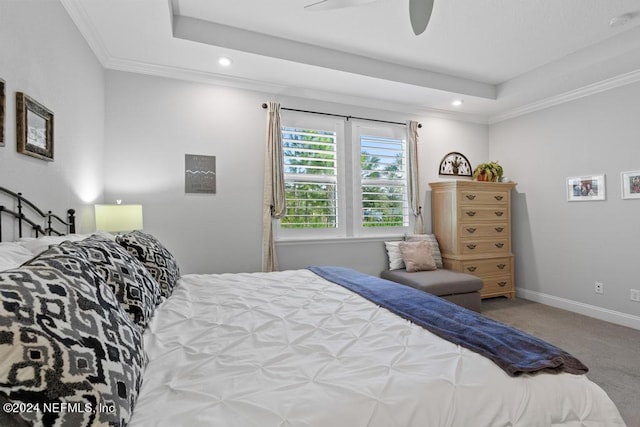 bedroom with carpet, crown molding, a tray ceiling, and ceiling fan