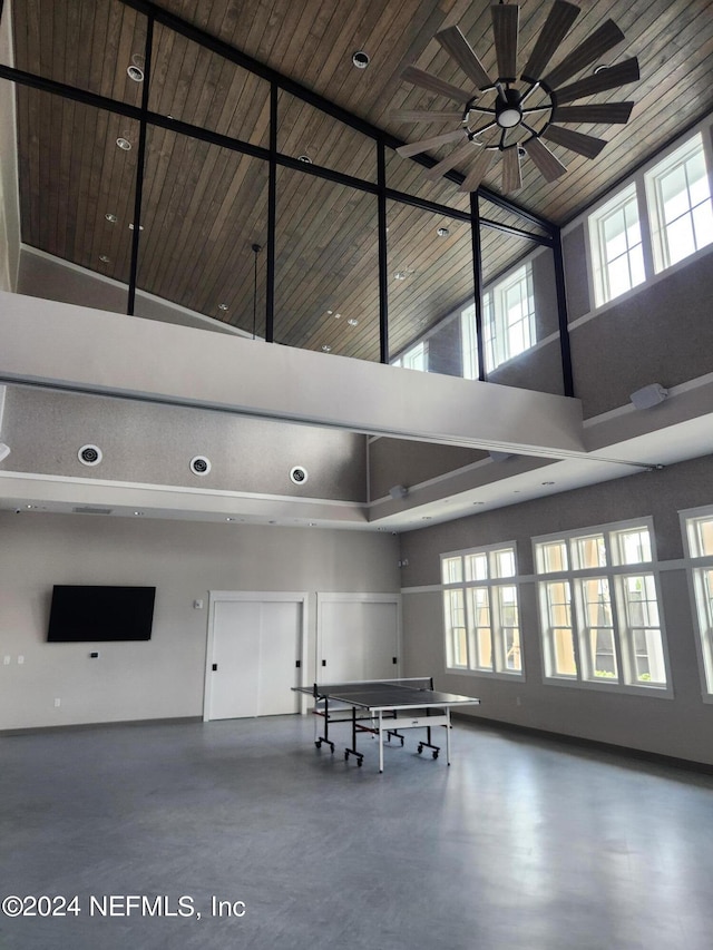 interior space with concrete floors, high vaulted ceiling, wood ceiling, and ceiling fan