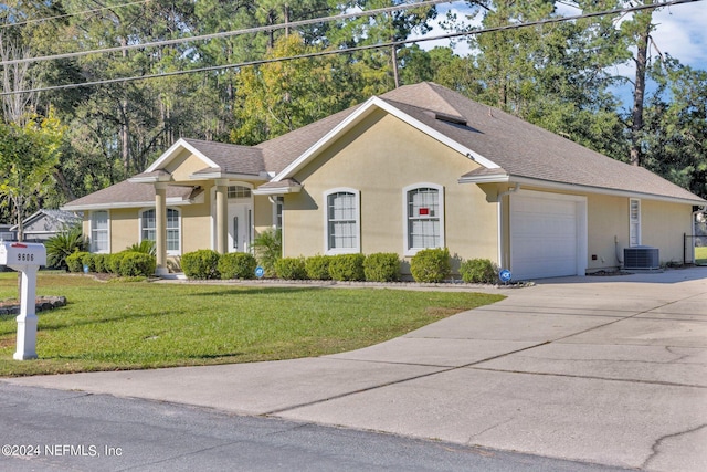 view of front of home with cooling unit, a front lawn, and a garage