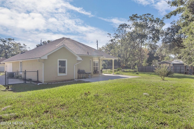 rear view of house with a patio area and a lawn