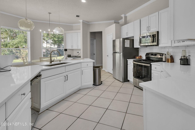 kitchen with sink, white cabinetry, hanging light fixtures, and stainless steel appliances