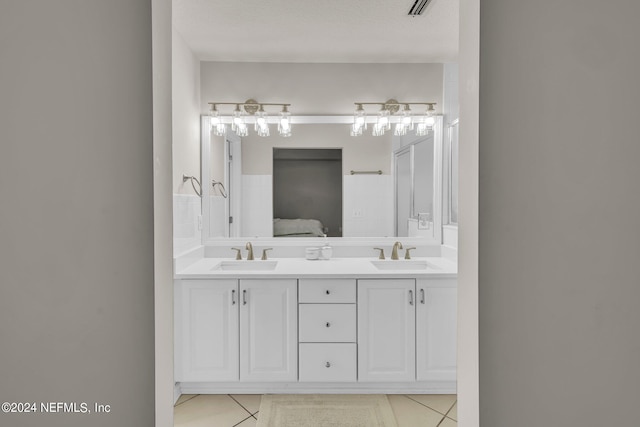 bathroom with vanity, a textured ceiling, and tile patterned flooring