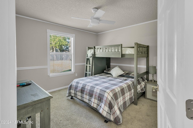 bedroom with ceiling fan, carpet flooring, a textured ceiling, and ornamental molding