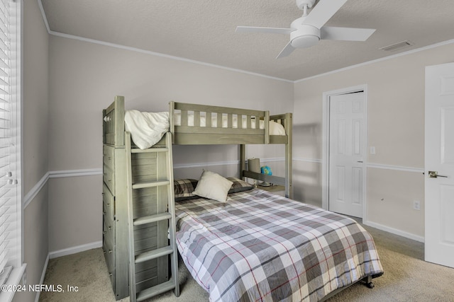 carpeted bedroom featuring crown molding, a textured ceiling, and ceiling fan