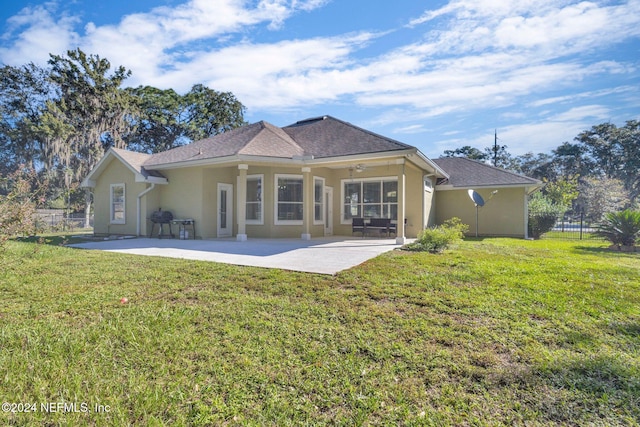 back of property featuring a patio area, a lawn, and ceiling fan