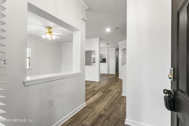 foyer featuring crown molding, dark hardwood / wood-style floors, a textured ceiling, and ceiling fan