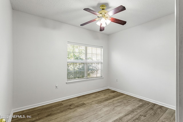 empty room with a textured ceiling, hardwood / wood-style flooring, and ceiling fan